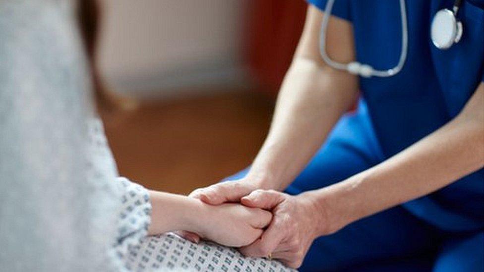 Nurse holding patient's hand