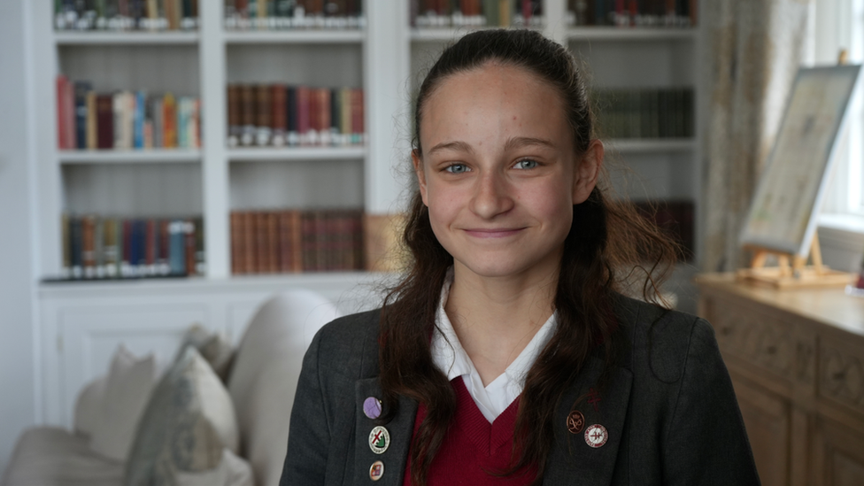 School pupil Olivia, sitting in school library