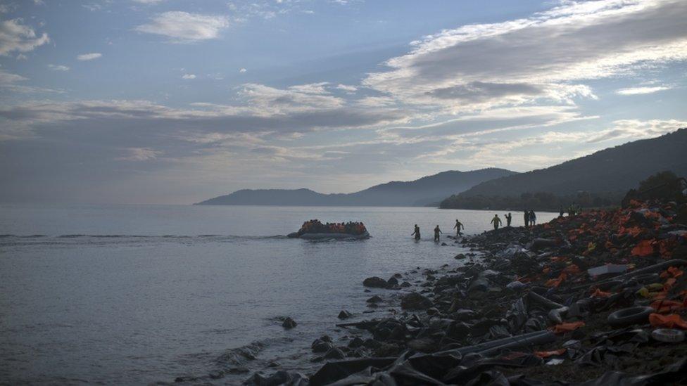 A boat carrying migrants arrives on the short of Lesbos, Greece