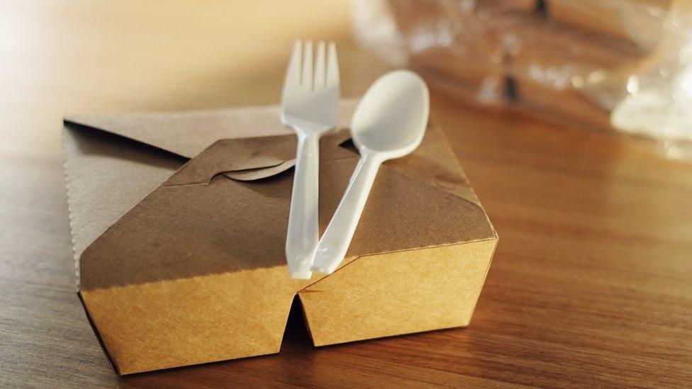 Plastic cutlery on top of a food box