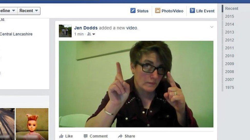 Jen Dodds points up at her name on a Facebook video