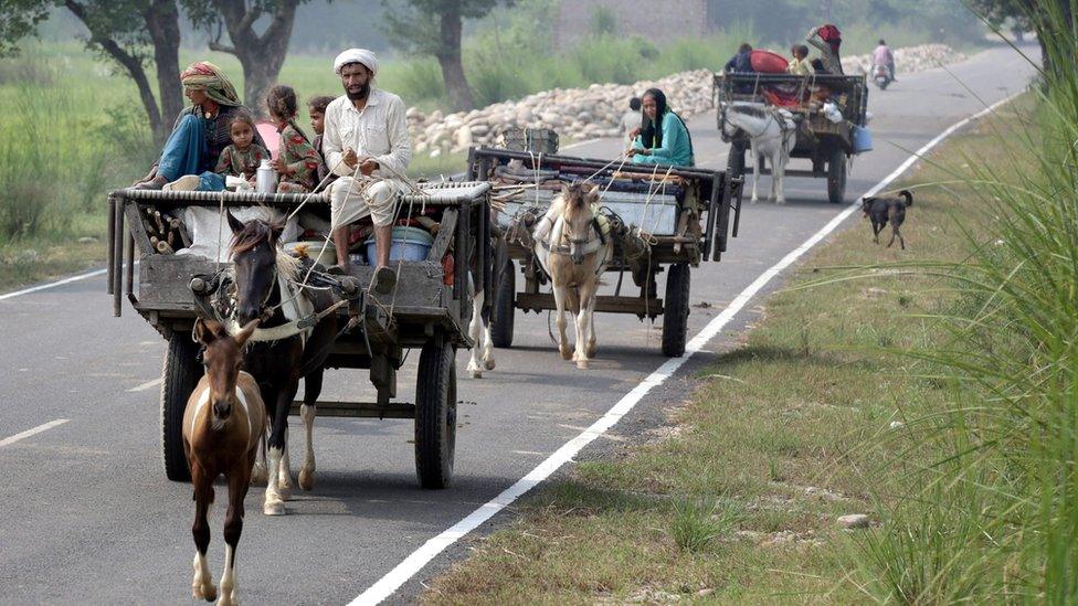 Indian border villagers travel in a cart as they move with their belongings to a safer place after authorities ordered the evacuation of villages near the Pakistan border, at Paloora village, about 55km from Jammu, the winter capital of Kashmir, India, 30 September 2016