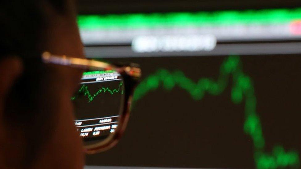 A woman looks at an electronic board showing the recent fluctuations of market indices on the floor of Brazil's B3 Stock Exchange in Sao Paulo, Brazil, April 3, 2019