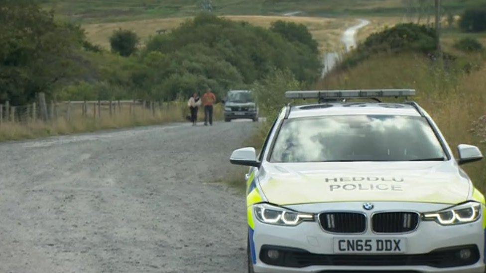 Police car at the entrance to the rave site