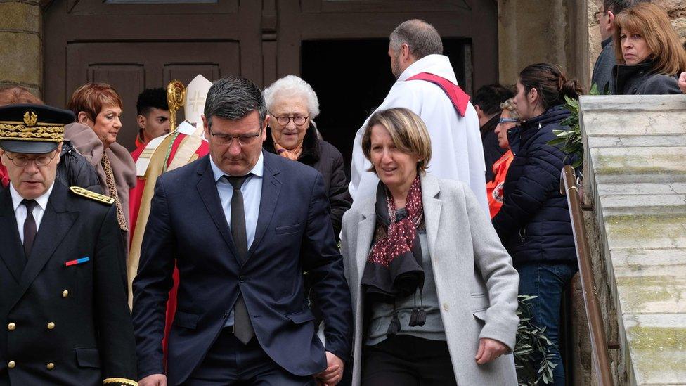 Mayor of Trebes Eric Menassi (centre) and his wife Director of Super U supermarket Samia Menassi (right) leave the remembrance service at the Saint Etienne Church in Trebes, southwest France.