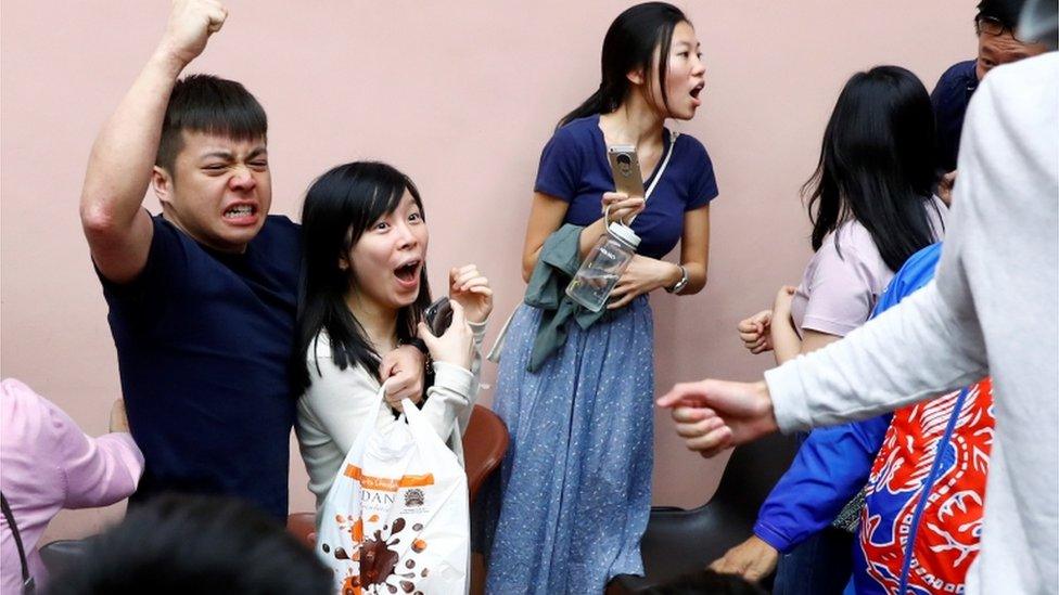 Supporters of local candidate Kelvin Lam celebrate after he wins his race in Hong Kong