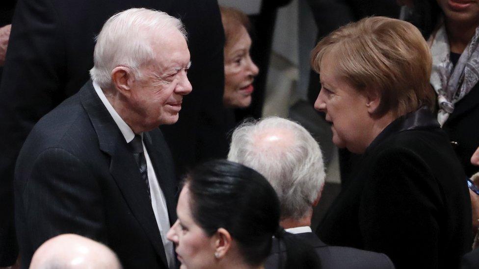 German Chancellor Angela Merkel speaking with former US president Jimmy Carter