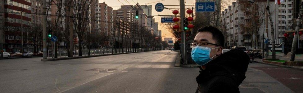 Image shows a Chinese man wearing a protective mask as a preventative measure