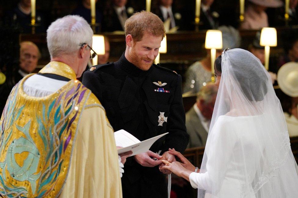 Prince Harry places the wedding ring on the finger of Meghan Markle in St George's Chapel