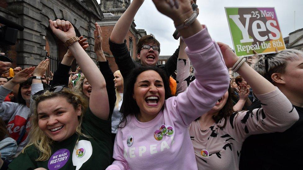 A crowd of Yes campaigners cheer and wave placards