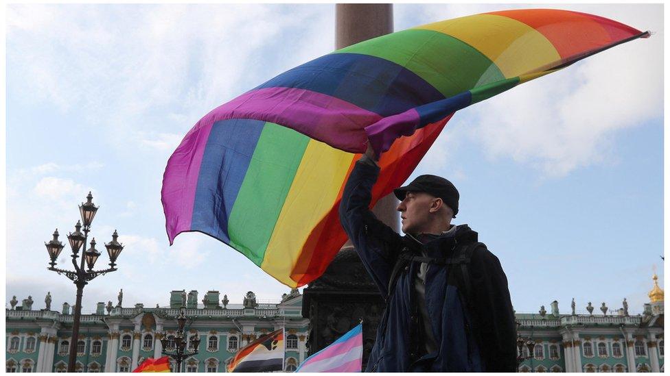 A participant waves a rainbow flag