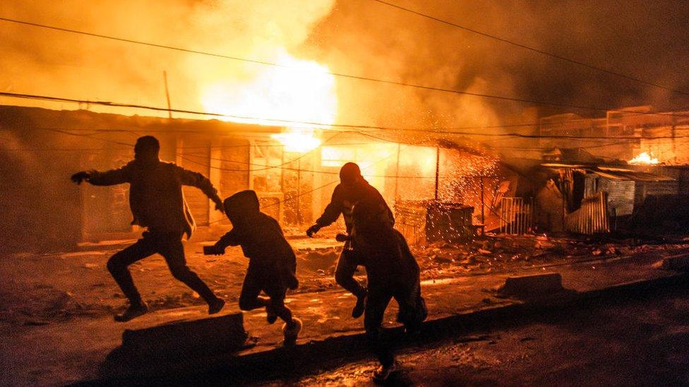 People run for cover following a series of explosions in the Embakasi area of Nairobi on February 2, 2024.