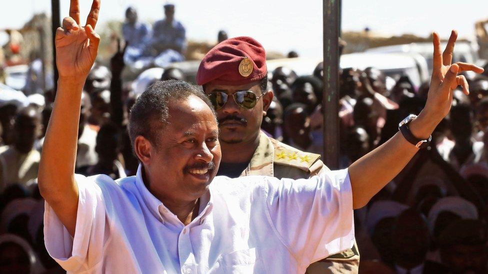 Prime Minister Abdalla Hamdok showing 'V' for victory signs