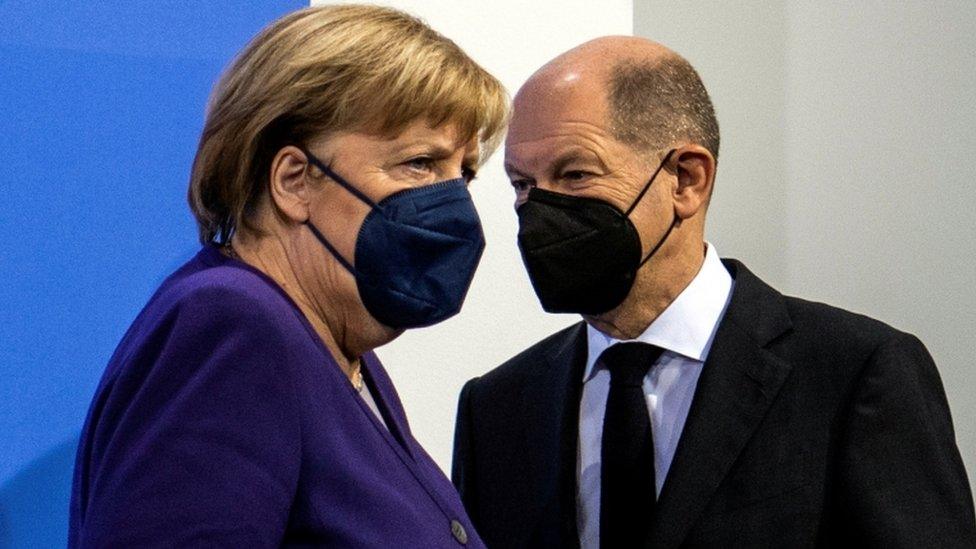 German Chancellor Angela Merkel and her designated successor Olaf Scholz arrive for a news conference on 2 December