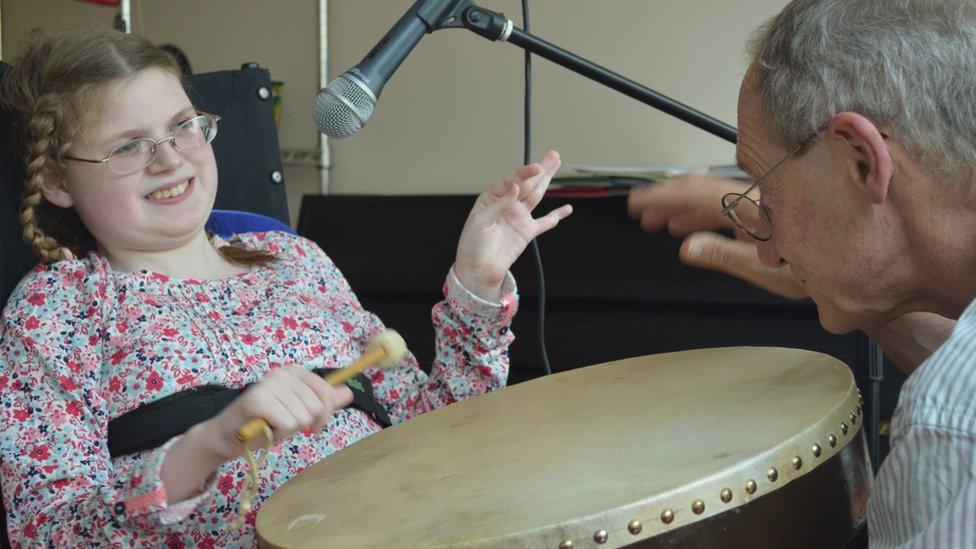 Charlotte playing drums with the music therapist at Helen House