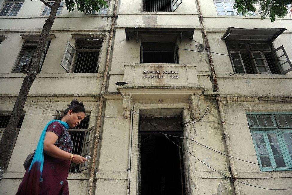 An Indian walks past the Pathare Prabhu building, due to be demolished to make way for a luxury apartment building, in Mumbai on June 24, 2011