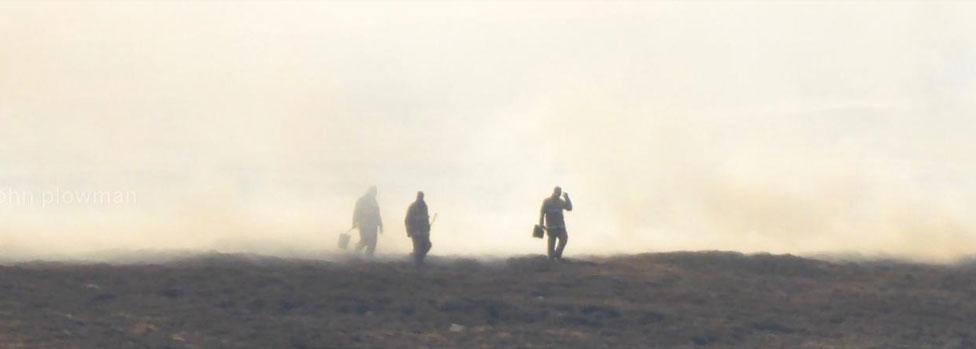 Firefighters in smoke from the blaze