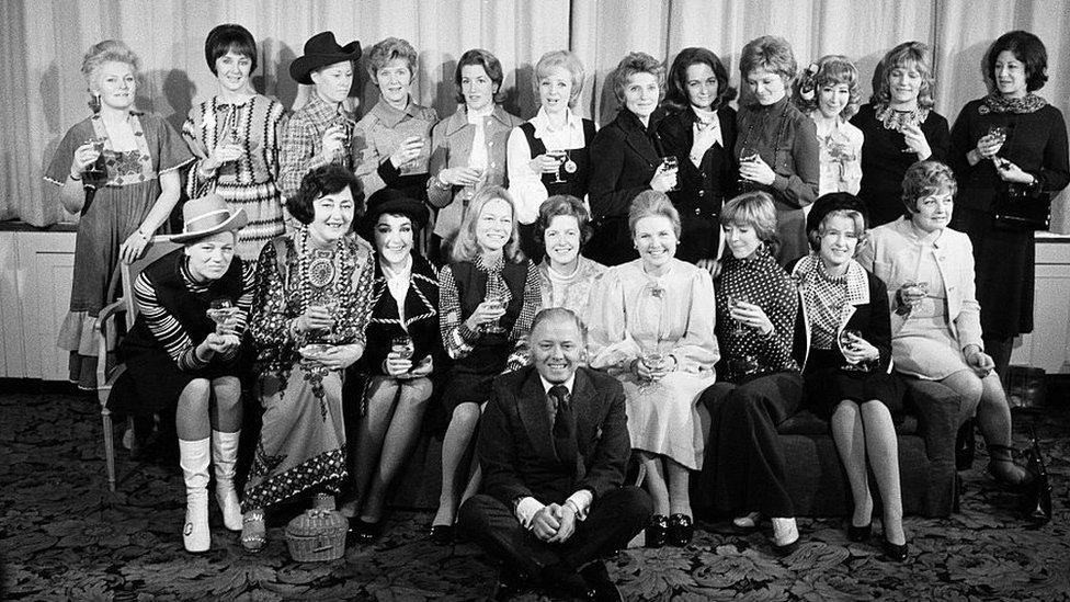 Attenborough and Sim posing with 20 of the show's leading ladies