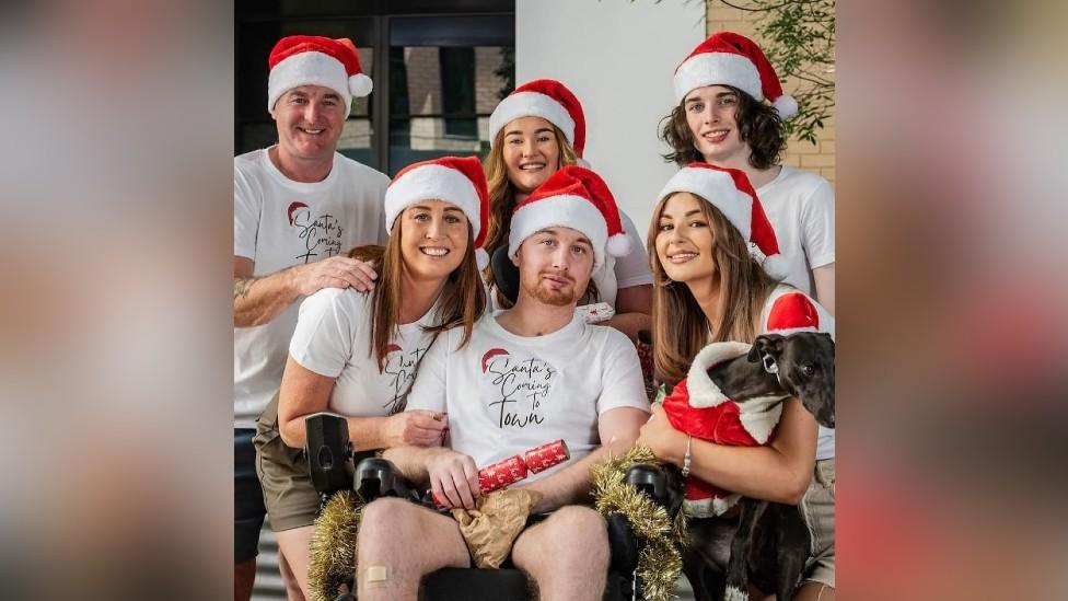 Danny and his family wearing Santa hats