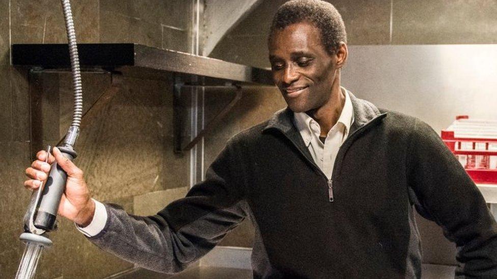 Employee Ali Sonko poses in the kitchen of Noma restaurant in Copenhagen