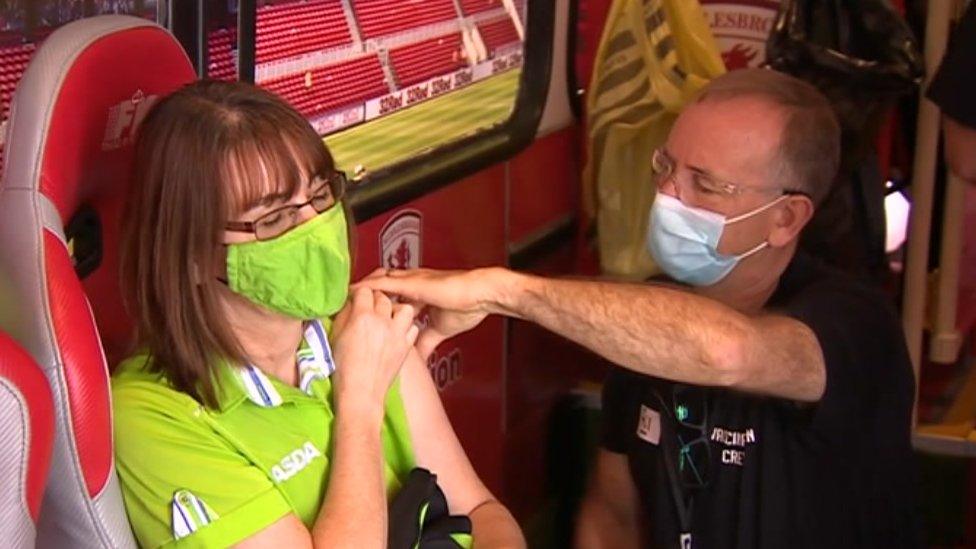 Woman in Asda uniform gets vaccination