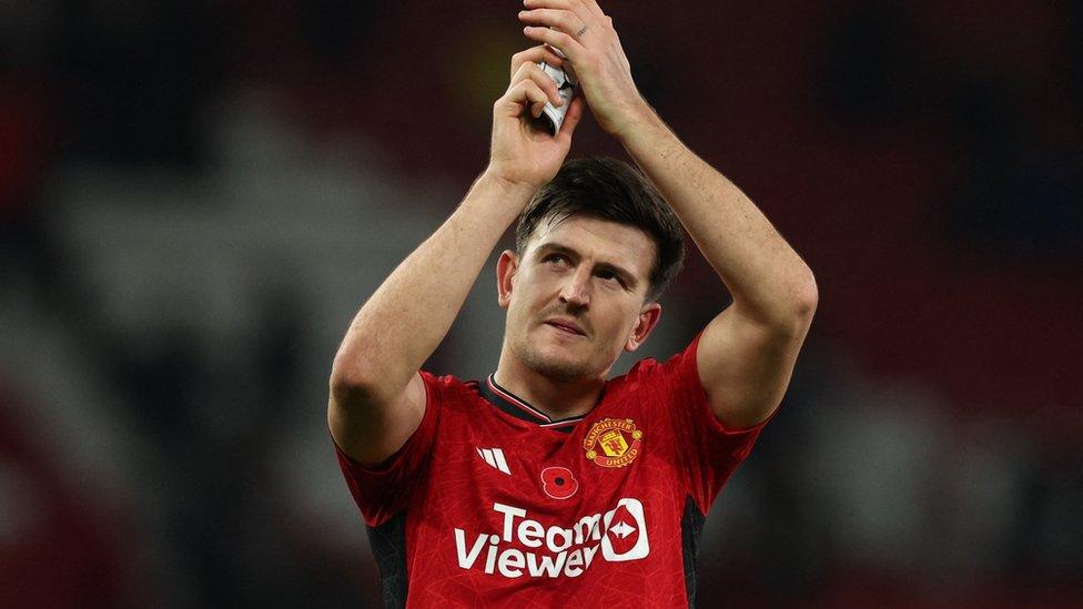 Harry Maguire clapping in a Manchester United shirt on the football pitch