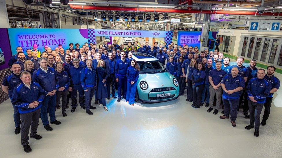 Workers at Mini Plant pose with new car