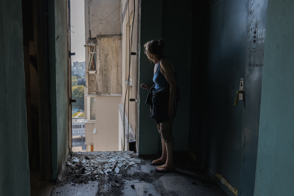 Larisa looks out from her hallway on the 16th floor. She is worried the building will collapse