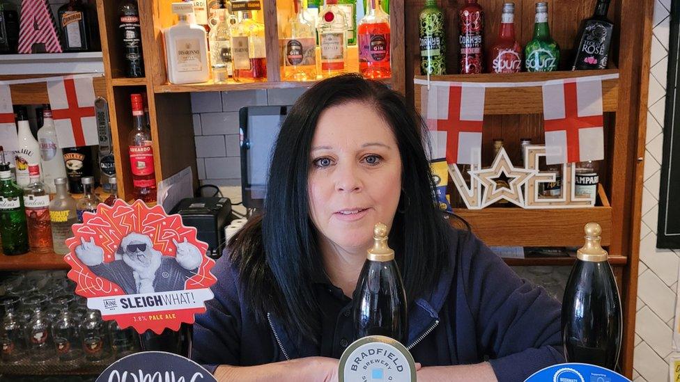 A pub landlady behind the bar