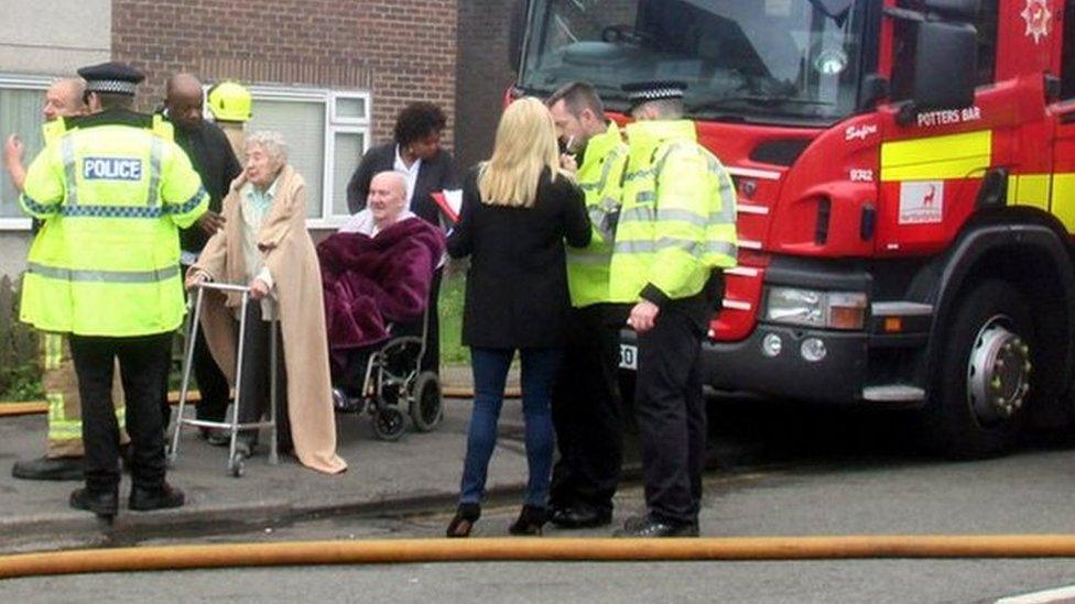 Elderly residents being helped to safety by the emergency services