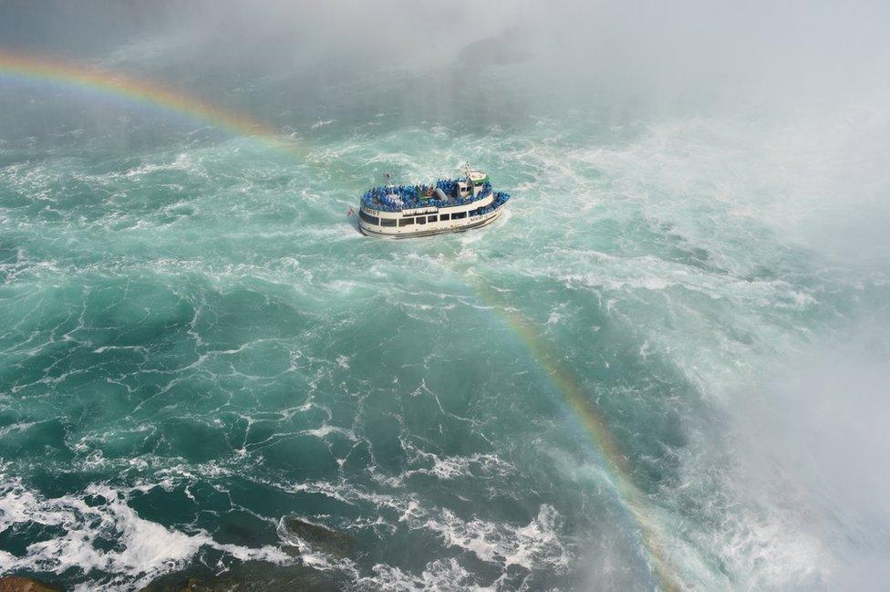 A boat crossed by a rainbow