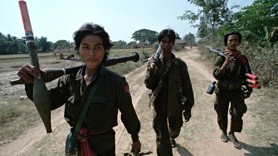 Heavily armed Cambodian government soldiers patrol on a remote 'road' in 1992