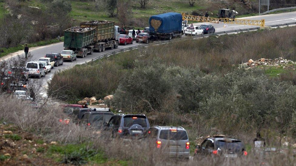 Palestinians queue to pass through an Israeli checkpoint set up in the occupied West Bank after the killing of an Israeli settler (10 January 2018)