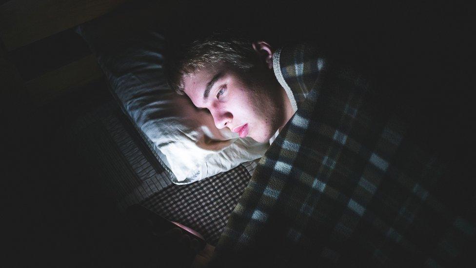 boy-struggling-to-sleep-with-mobile-phone