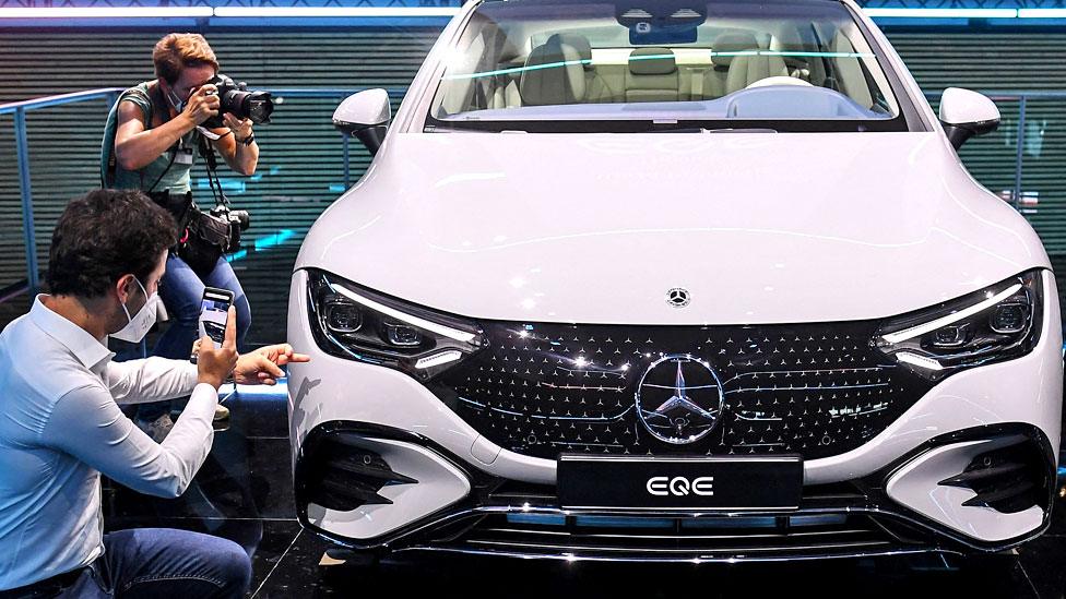 Journalists photograph car on display at the motor show