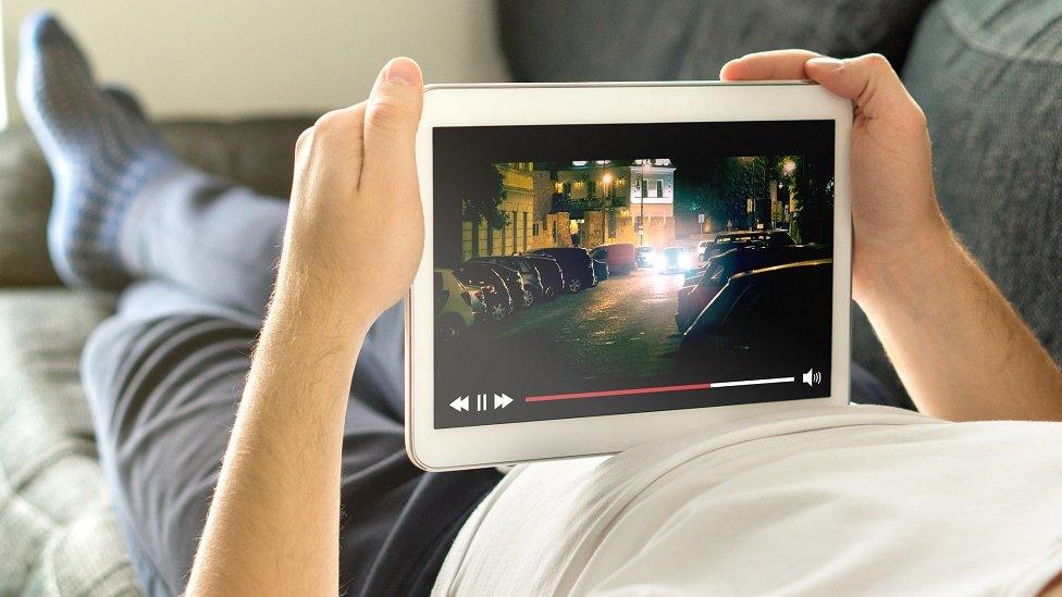 Man watching tablet on sofa