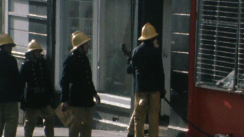 A number of firemen on the day Yvonne Dunlop was killed in October 1976 walking into a burnt out building