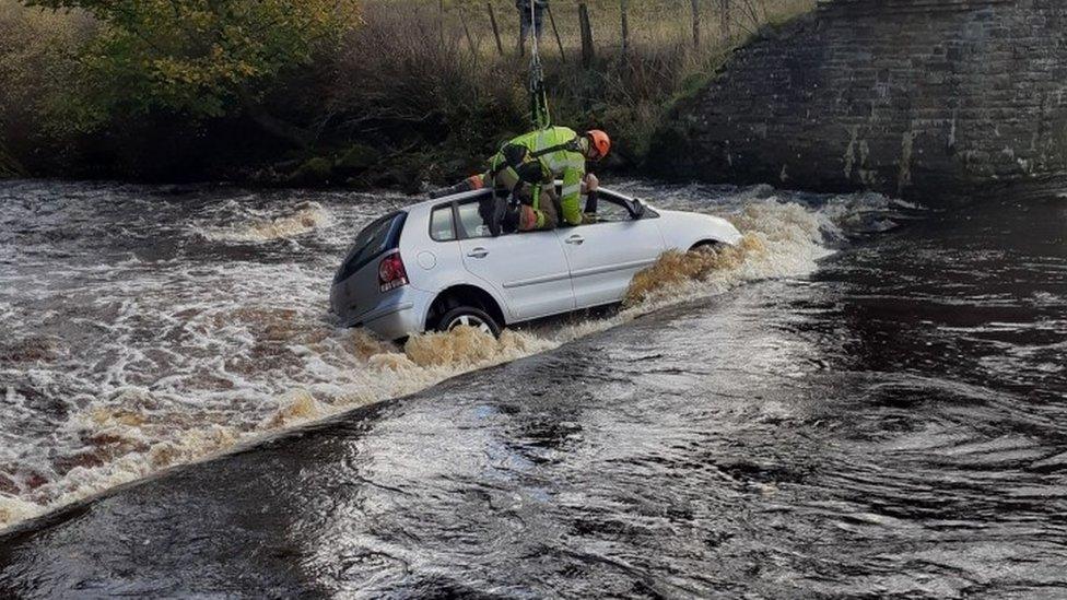 Car in river and rescue being carried out