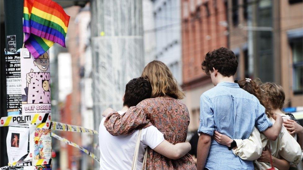 People react next to a cordoned-off crime scene in the aftermath of shootings in the centre of Oslo, Norway. Photo: 25 June 2022