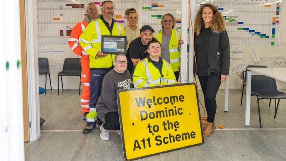 Dominic and members of National Highways with a personalised traffic management sign