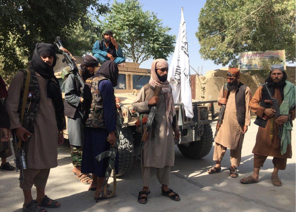 Taliban fighters in Balkh, with captured Humvee