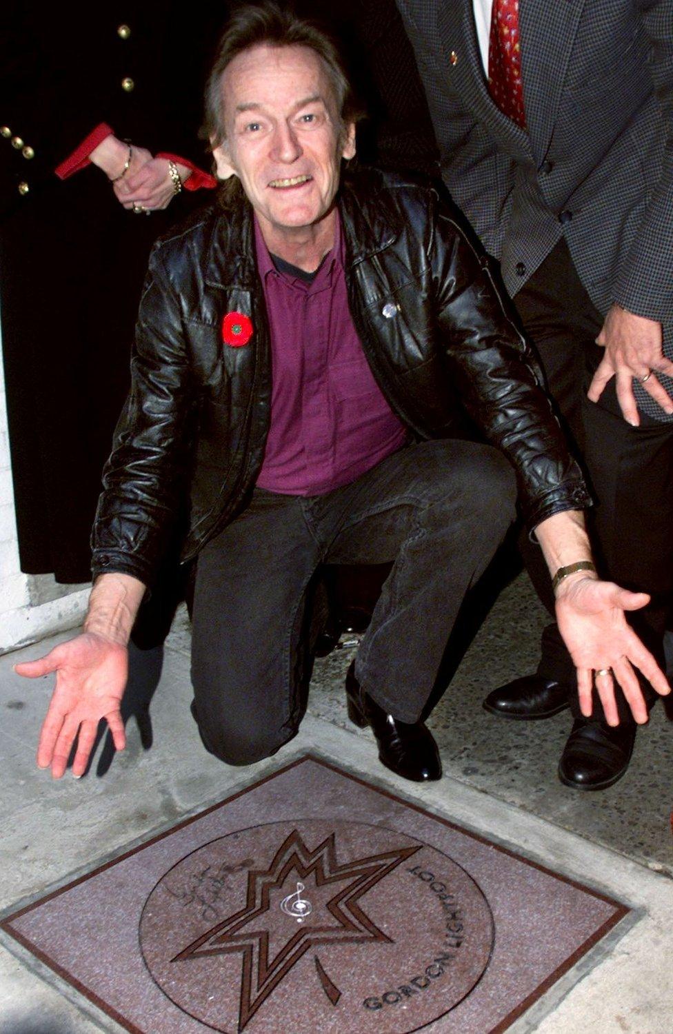 Gordon Lightfoot shows off his star on the Walk of Fame in Toronto in November 1998