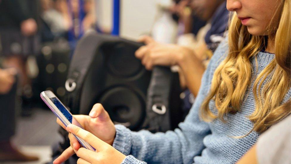 girl-on-train-using-phone.