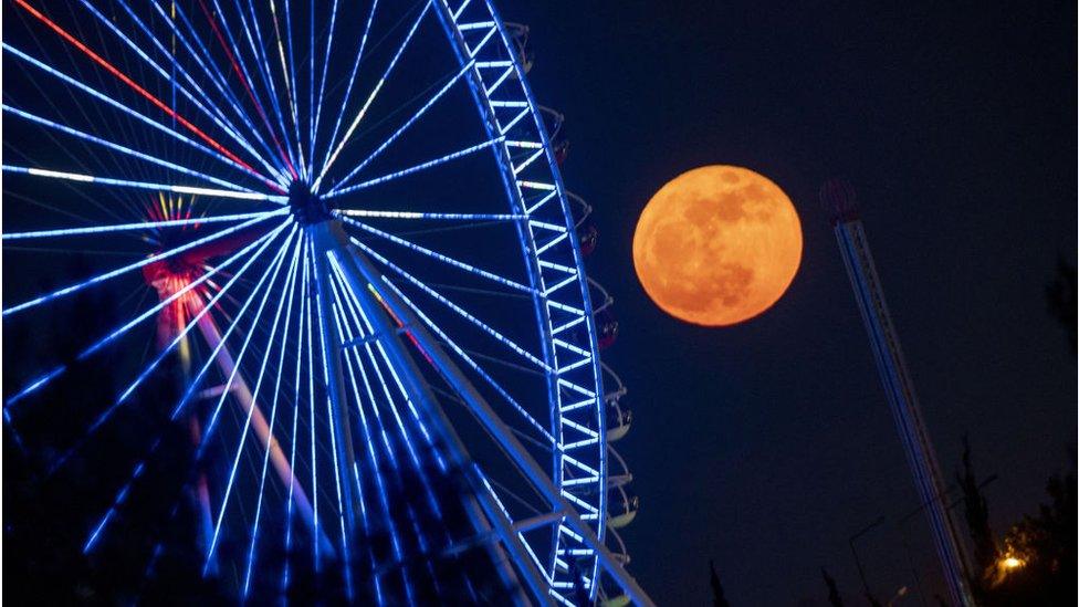 Here the moon can be seen behind a fair in Antalya, Turkey.