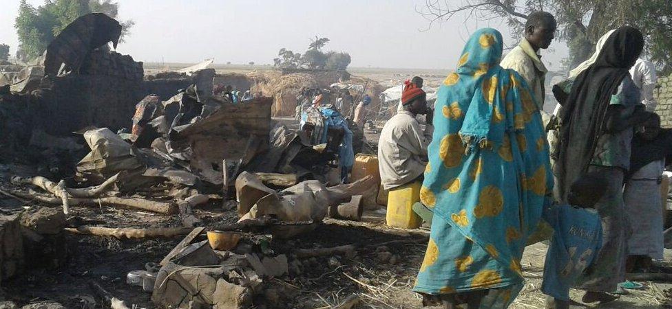 People walk at the site after a bombing attack of an internally displaced persons camp in Rann, Nigeria January 17, 2017.