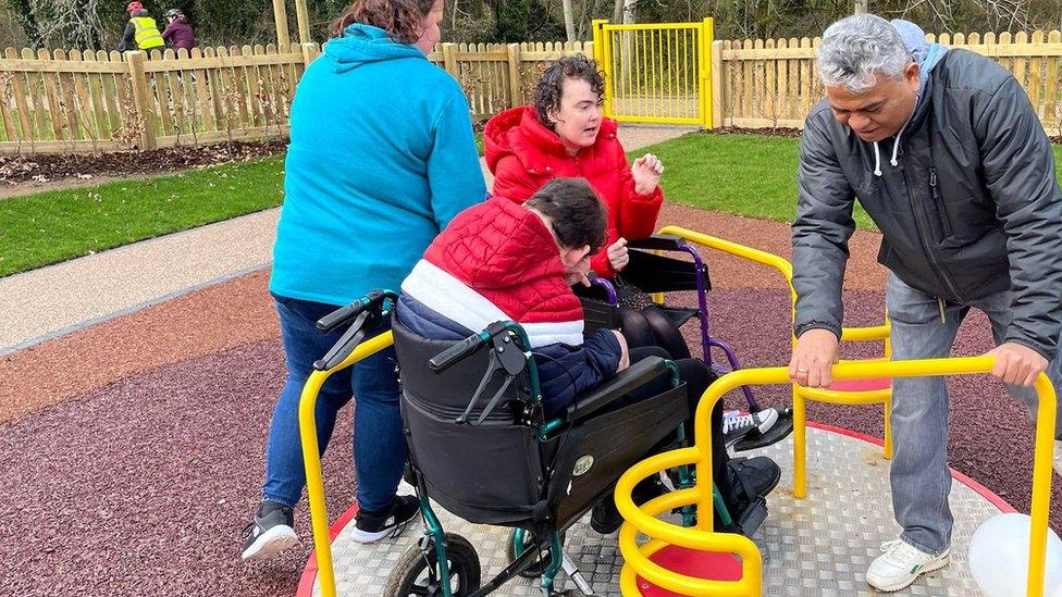 People using the wheelchair-accessible roundabout