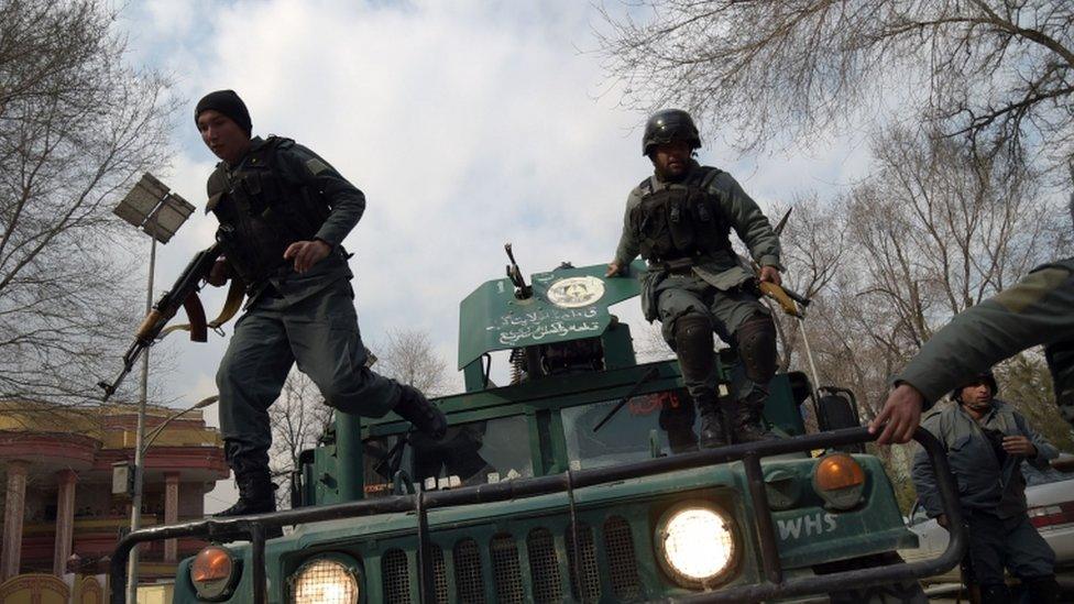 Afghan policemen leaping from a vehicle as they arrive outside a military hospital during an attack in Kabul.