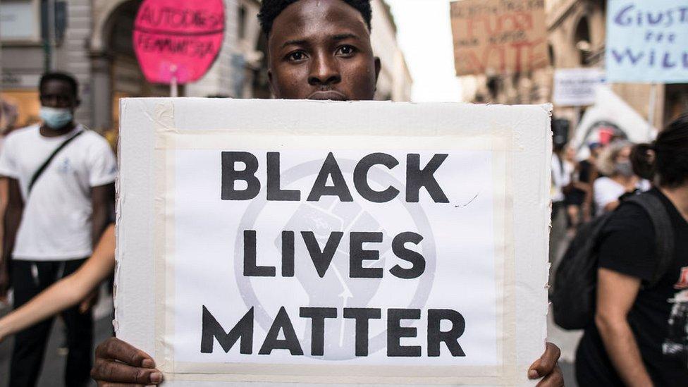 Man with a banner reading "Black Lives Matter" during a protest against racism by the Black Lives Matter movement on September 13, 2020 in Turin, Italy