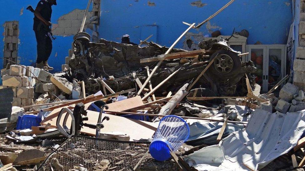 A member of the security forces stands on the scene of a car bomb attack in Mogadishu, in the southern district of Wadajir on June 20, 2017.