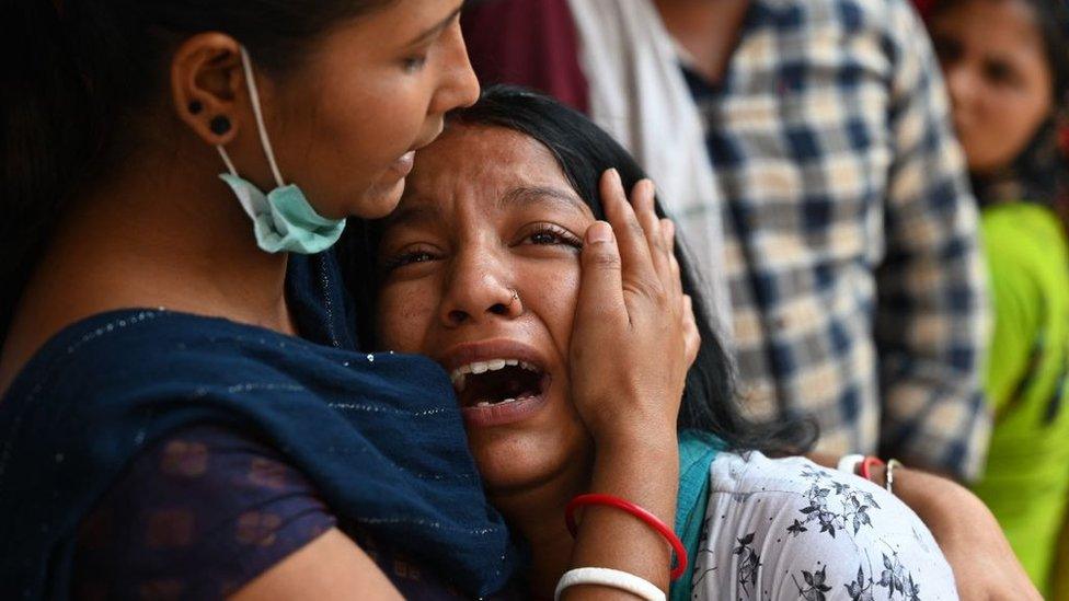 Relatives grieve outside the Sanjay Gandhi Memorial Hospital in Delhi on 14 May